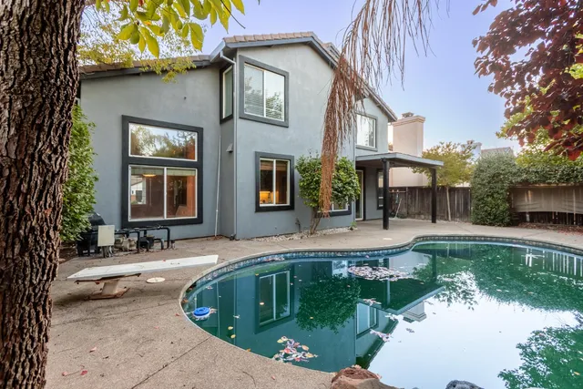 a view of a house with pool and sitting area