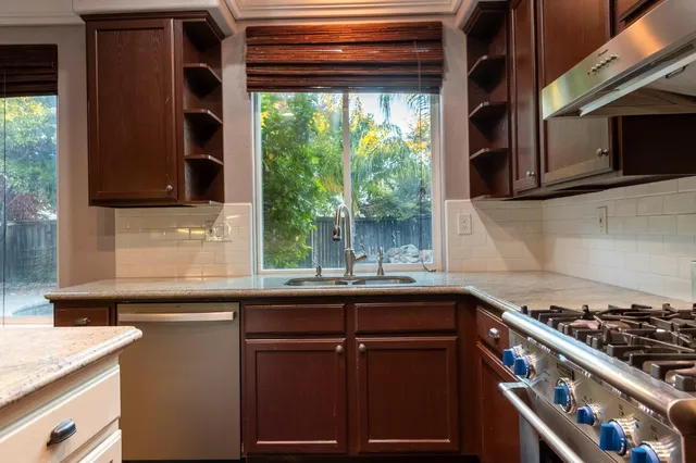 a kitchen with a sink stove top oven and cabinets