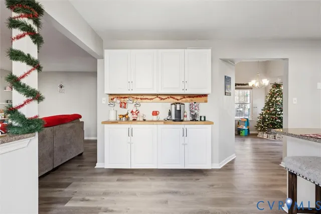 a kitchen with stainless steel appliances white cabinets and wooden floor