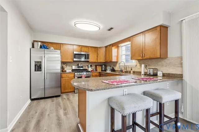 a kitchen with stainless steel appliances granite countertop a stove refrigerator sink and cabinets