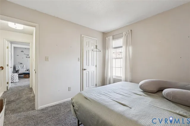 a bedroom with a large bed and a flat tv screen on dresser