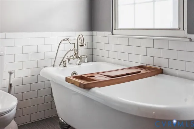 a view of a backyard with large trees and wooden fence
