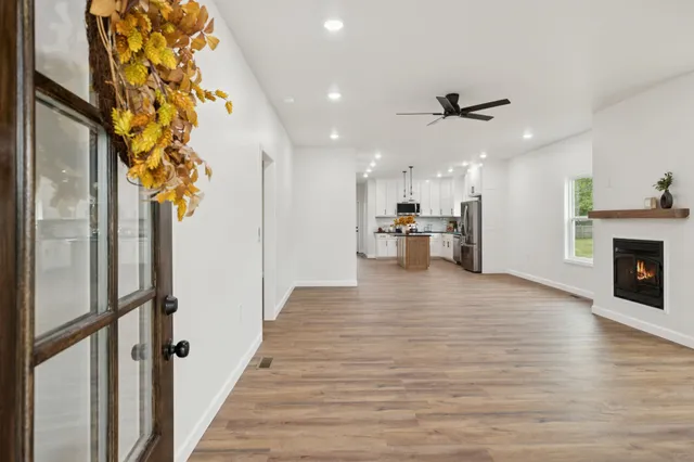 a view of empty room with wooden floor and a fireplace