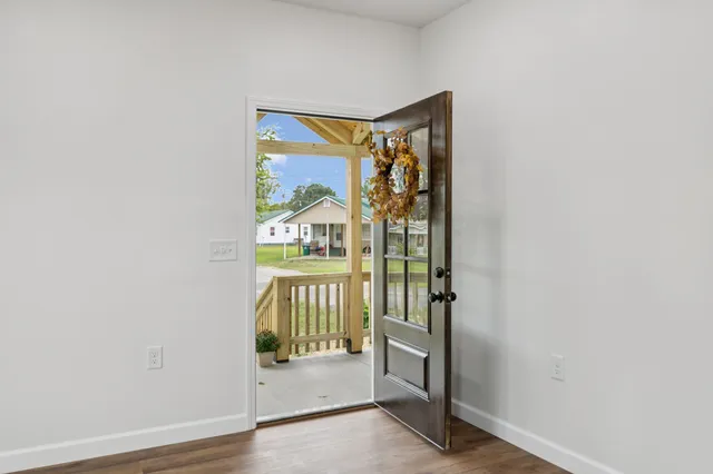 a view of an empty room with a fireplace and a window