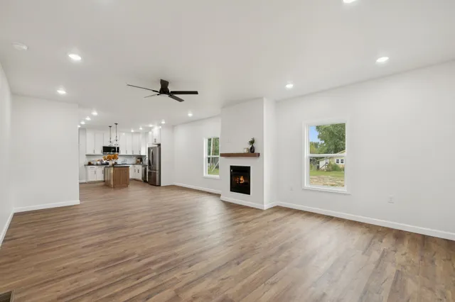 a view of an empty room with a fireplace and a window