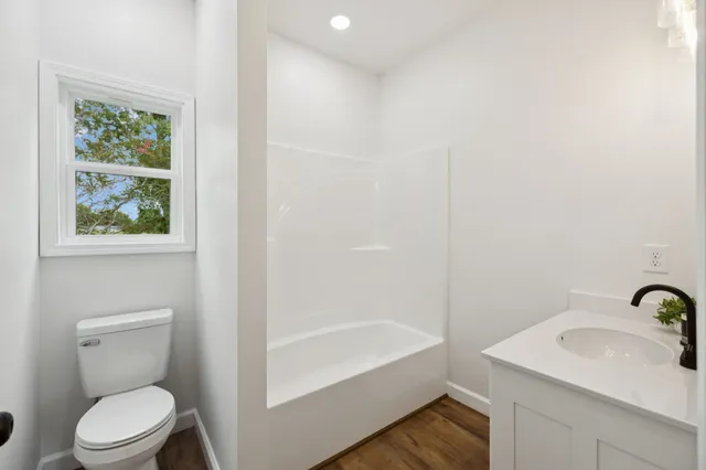 a white house that has tree in front of it