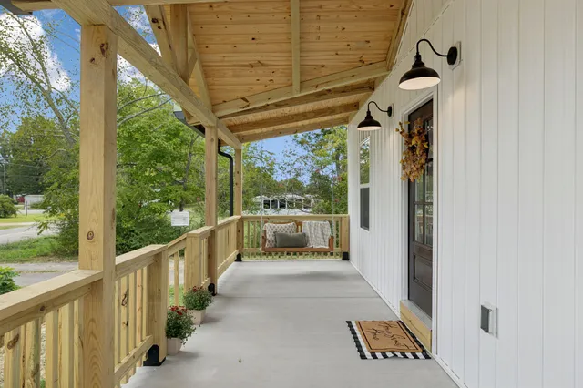an empty room with wooden floor a fireplace and windows