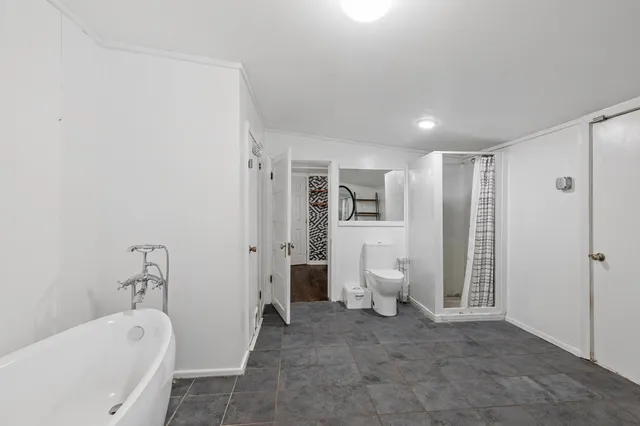 a spacious bathroom with a bathtub and a toilet