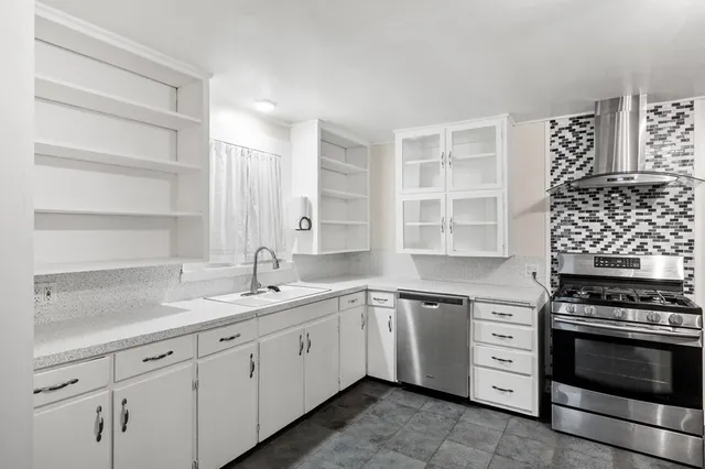 a kitchen with granite countertop a stove sink and cabinets