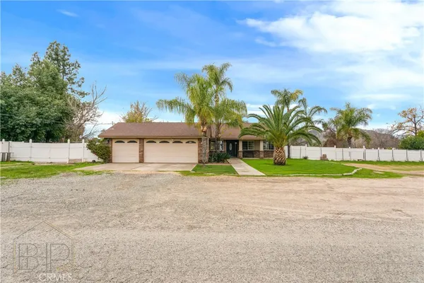a view of a house with a yard and palm trees