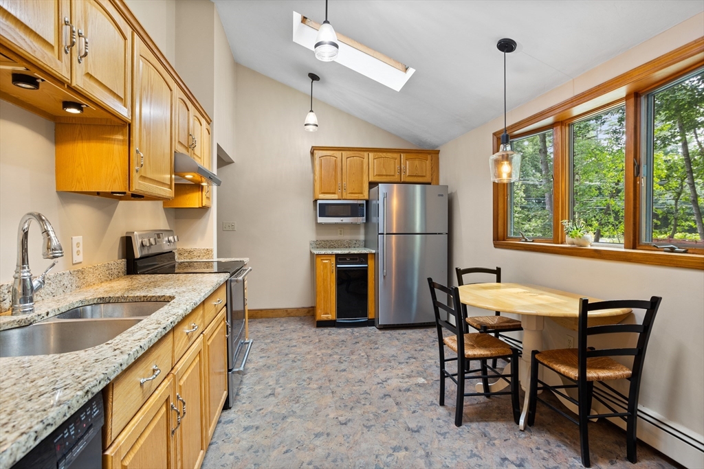 773 Great Road Stow, MA 01775 - Photo 12 of 37 a kitchen with a table chairs refrigerator and cabinets