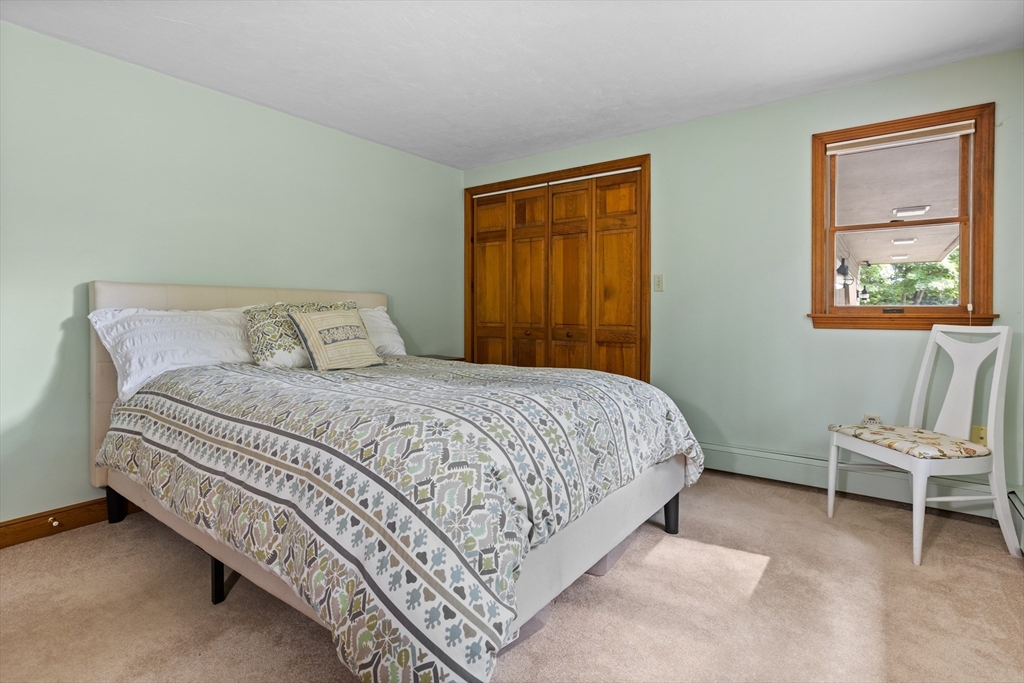 773 Great Road Stow, MA 01775 - Photo 18 of 37 a bedroom with a bed and a chair