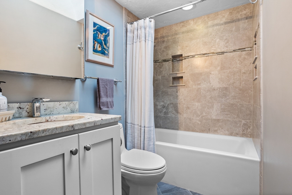 773 Great Road Stow, MA 01775 - Photo 19 of 37 a bathroom with a granite countertop sink toilet and shower