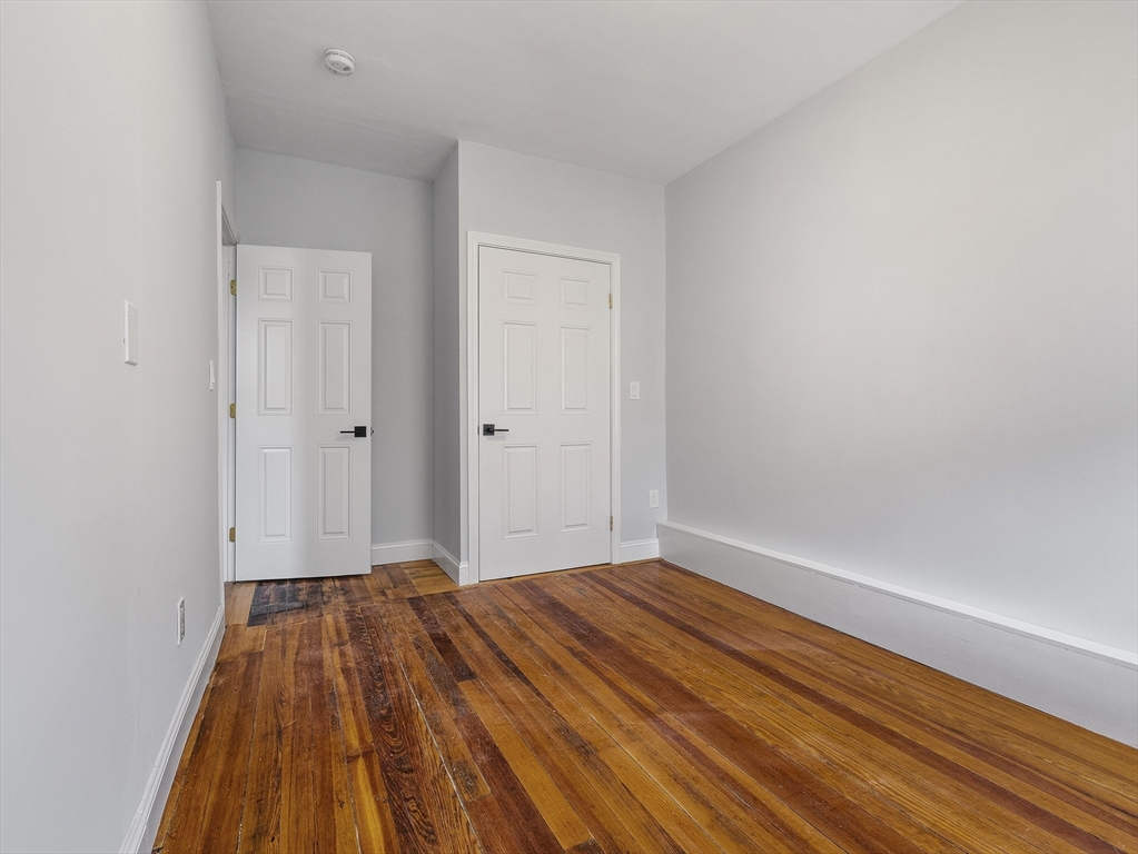 131 A Cottage Street, Unit 2A Boston, MA 02128 - Photo 13 of 16 a view of a room with wooden floor and a ceiling fan