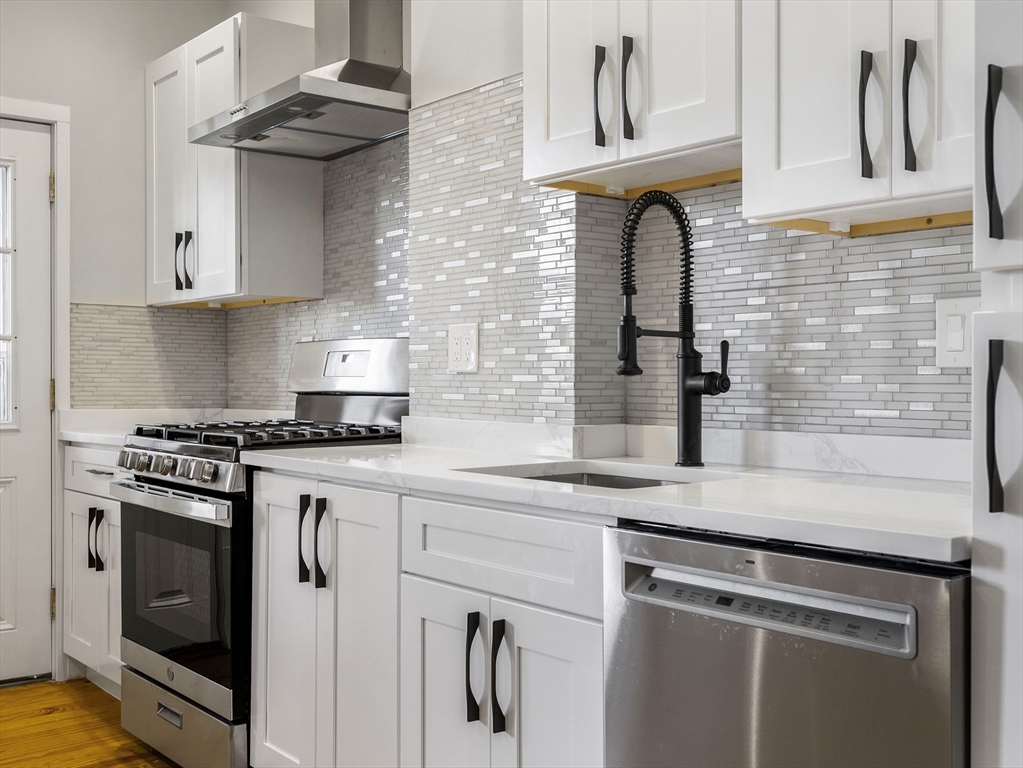 131 A Cottage Street, Unit 2A Boston, MA 02128 - Photo 3 of 16 a kitchen with stainless steel appliances granite countertop white cabinets and a stove