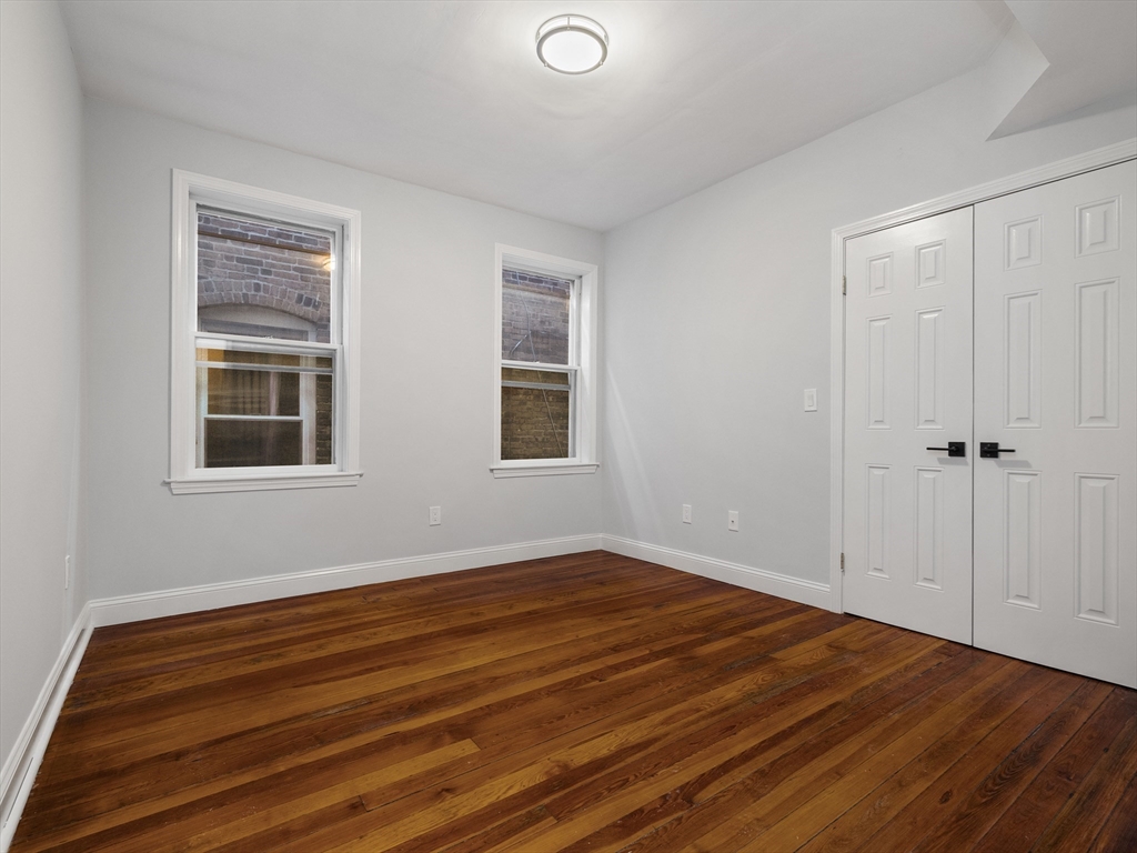 131 A Cottage Street, Unit 2A Boston, MA 02128 - Photo 7 of 16 a view of an empty room with wooden floor and a window