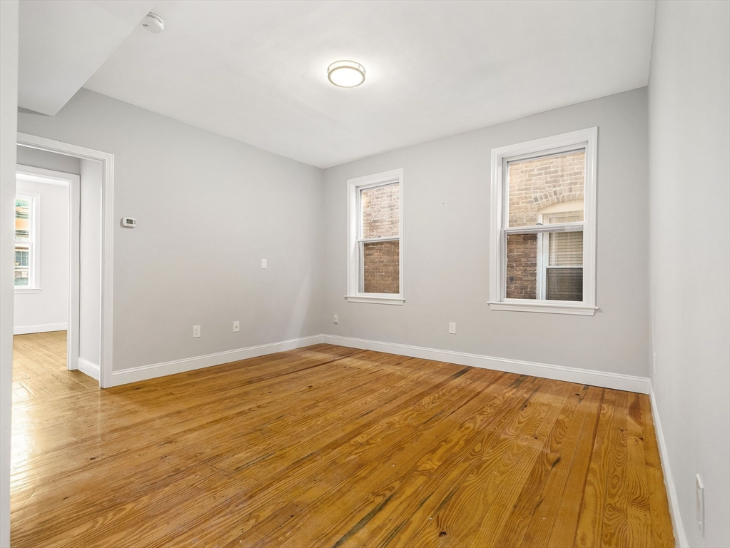 131 A Cottage Street, Unit 2A Boston, MA 02128 - Photo 8 of 16 a view of an empty room with wooden floor and a window