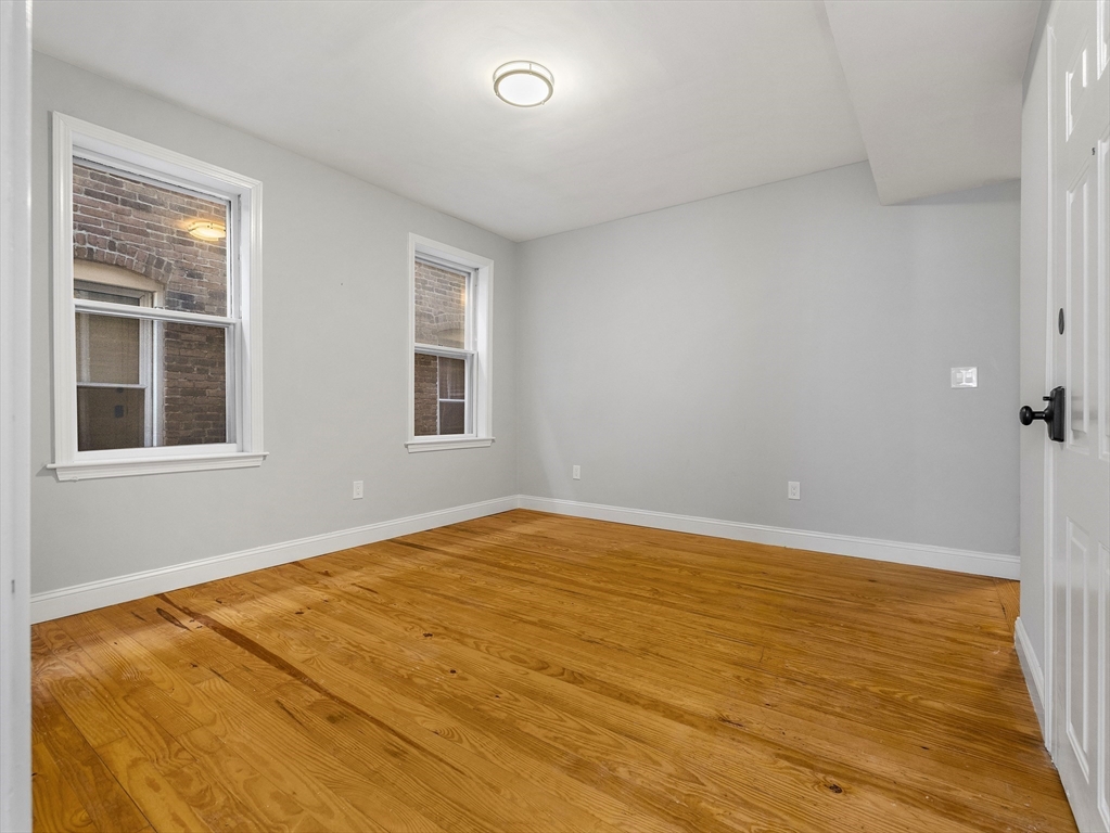 131 A Cottage Street, Unit 2A Boston, MA 02128 - Photo 9 of 16 a view of empty room with wooden floor and fan