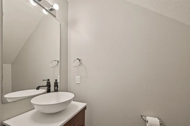 a bathroom with a sink a toilet a mirror and shower