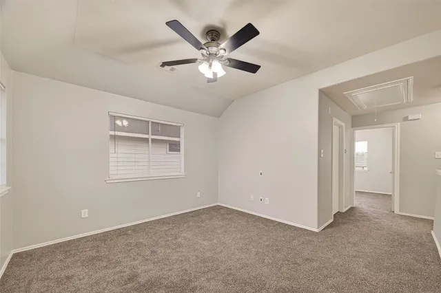 a view of an empty room with a ceiling fan and a window