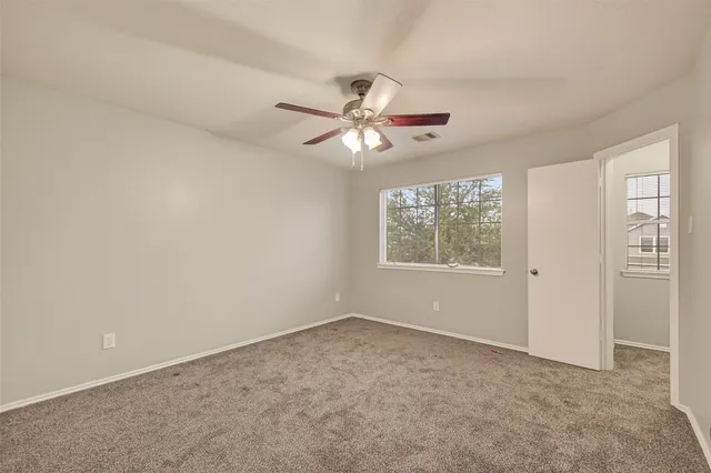 a view of a room with a ceiling fan and a window