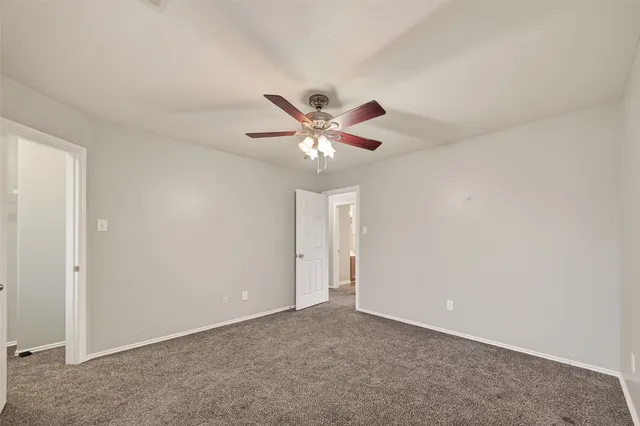 an empty room with closet and ceiling fan