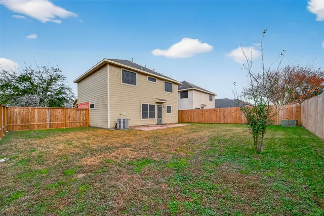 a view of a house with a yard and fence