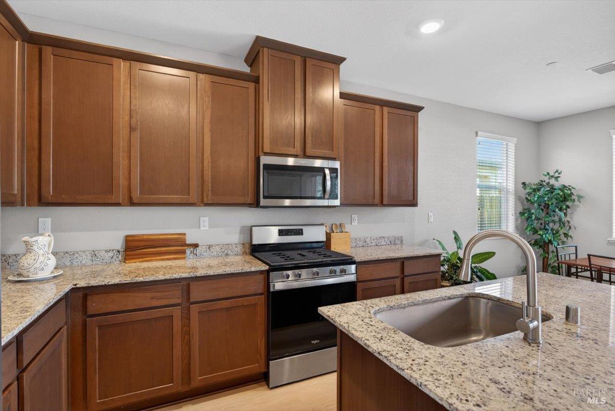 2275 Revival Lane Rio Vista, CA 94571 - Photo 6 of 31 a kitchen with granite countertop stainless steel appliances a sink a stove and a microwave