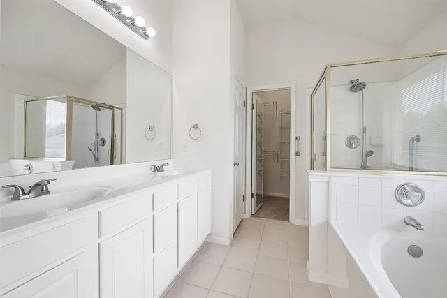 a spacious bathroom with a bathtub sink double and mirror