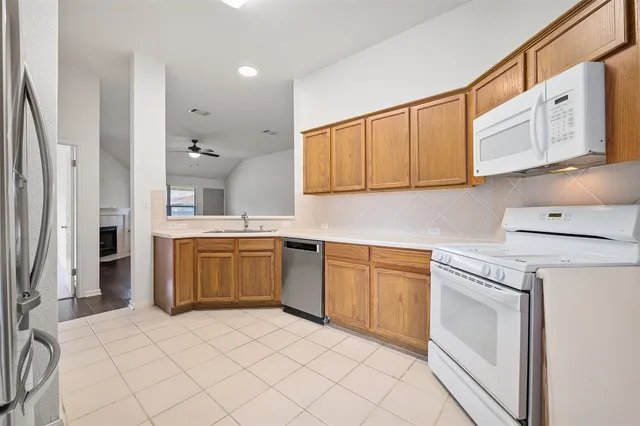 a kitchen with a refrigerator sink and cabinets