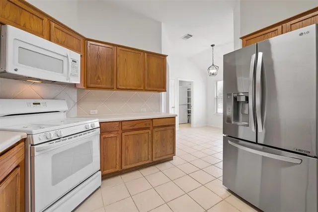 a kitchen with stainless steel appliances granite countertop a refrigerator and a stove top oven