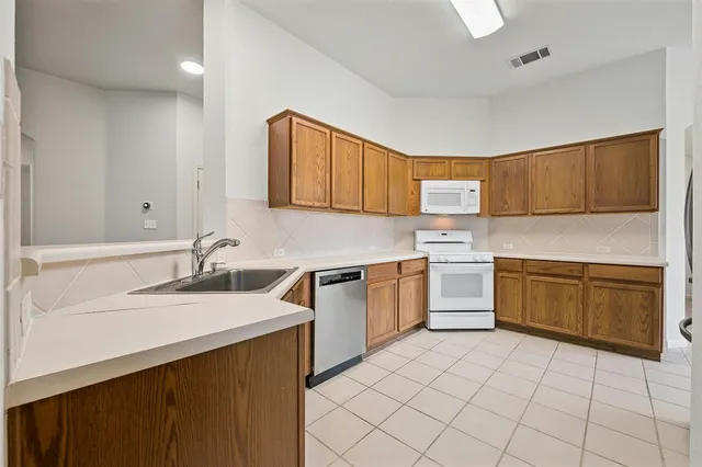 a kitchen with a sink stove top oven and cabinets
