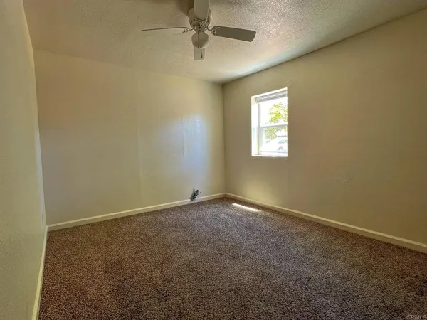 a front view of house with yard and trees in the background