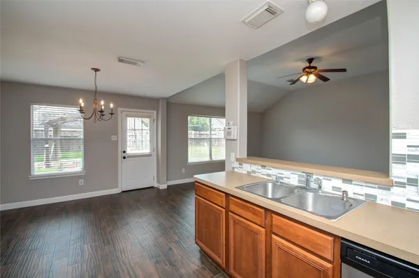 a view of a kitchen sink and dishwasher with wooden floor