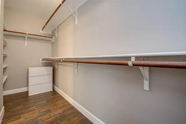 a view of walk in closet with empty racks