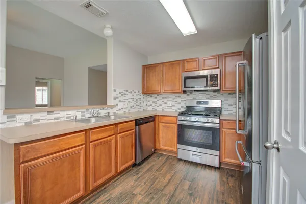 a kitchen with stainless steel appliances granite countertop a sink and cabinets