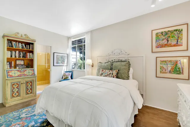 a bedroom with a bed and painting on the wall