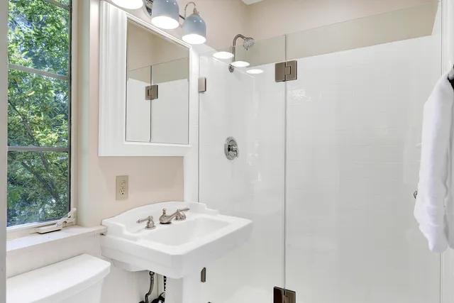 a bathroom with a sink a toilet and shower