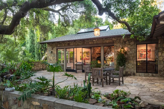 a view of a patio with table and chairs potted plants and large tree