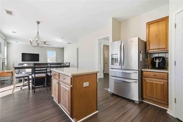 a kitchen with kitchen island wooden floors appliances and cabinets