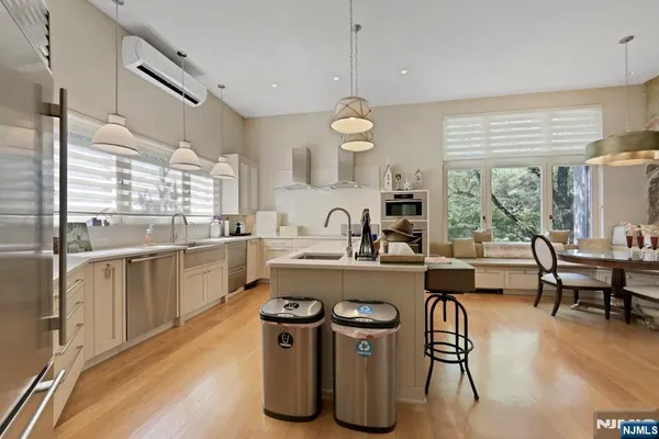 a kitchen with a sink dishwasher a stove a dining table and chairs with wooden floor