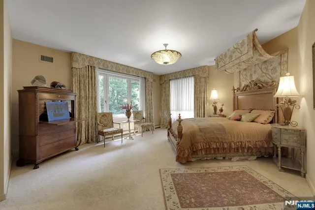 a spacious bedroom with a bed and a chandelier