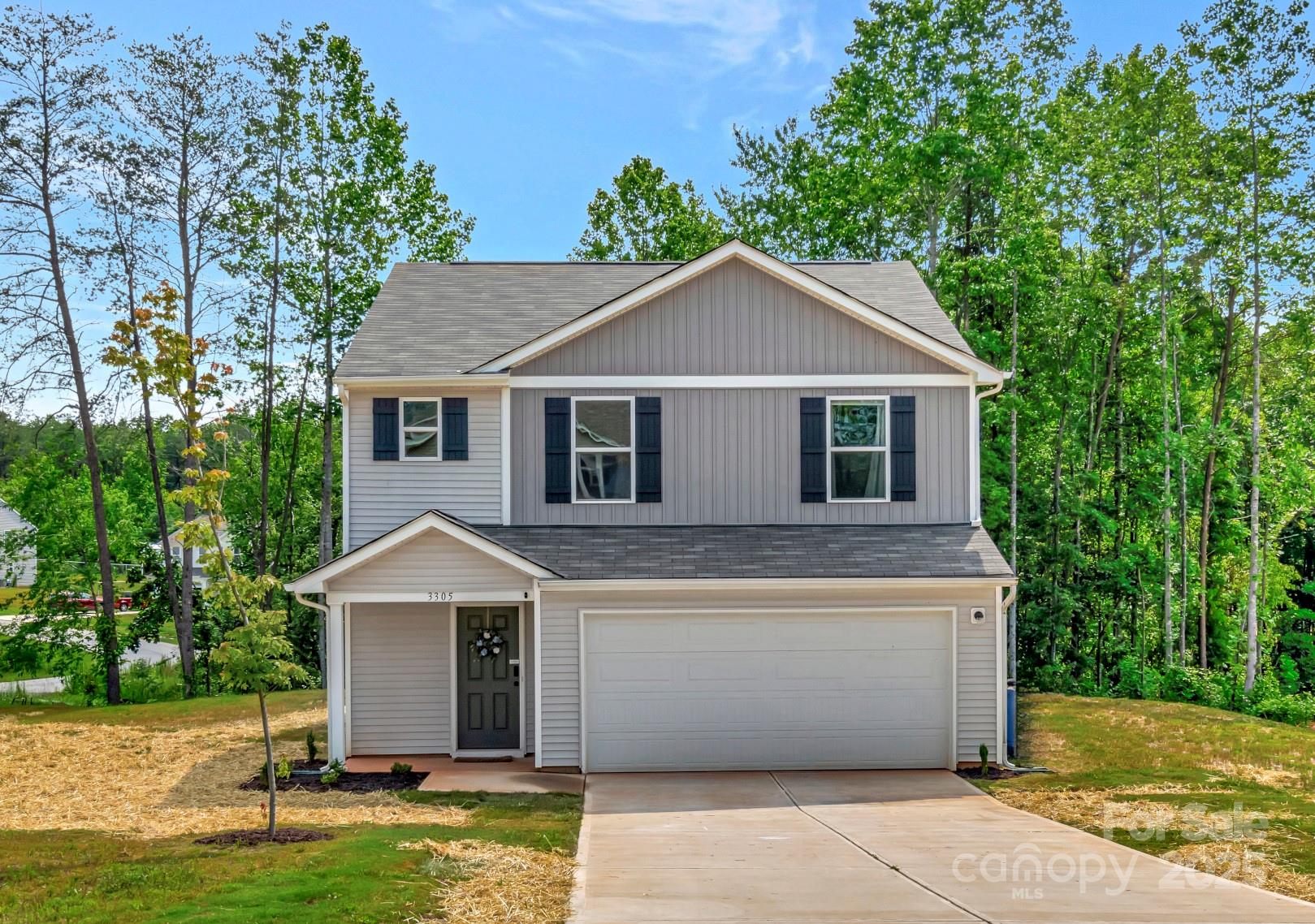 a view of a yard in front of a house with large windows
