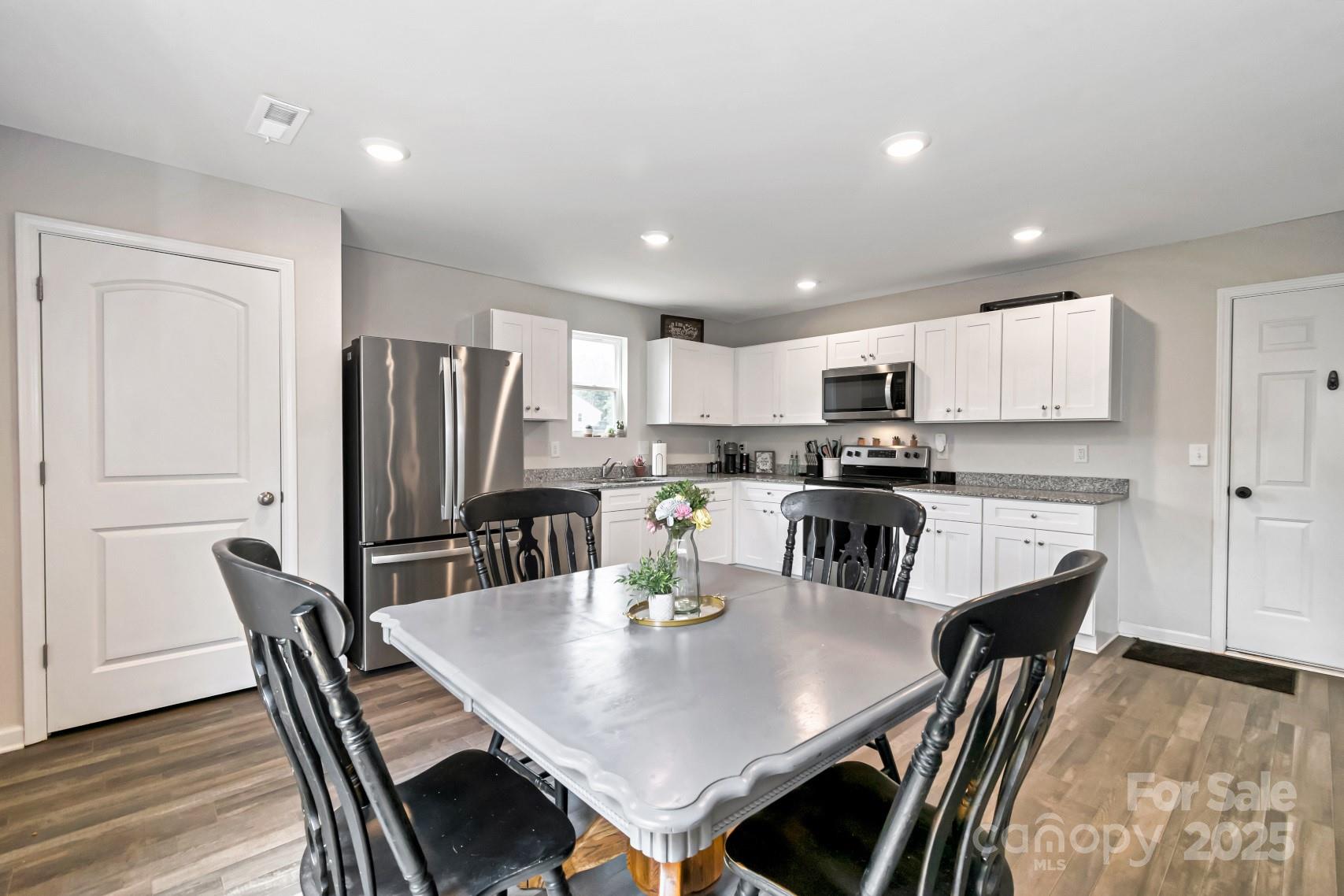 3305 Rian Drive Lenoir, NC 28645 - Photo 4 of 40 a kitchen with stainless steel appliances granite countertop a dining table chairs refrigerator and microwave