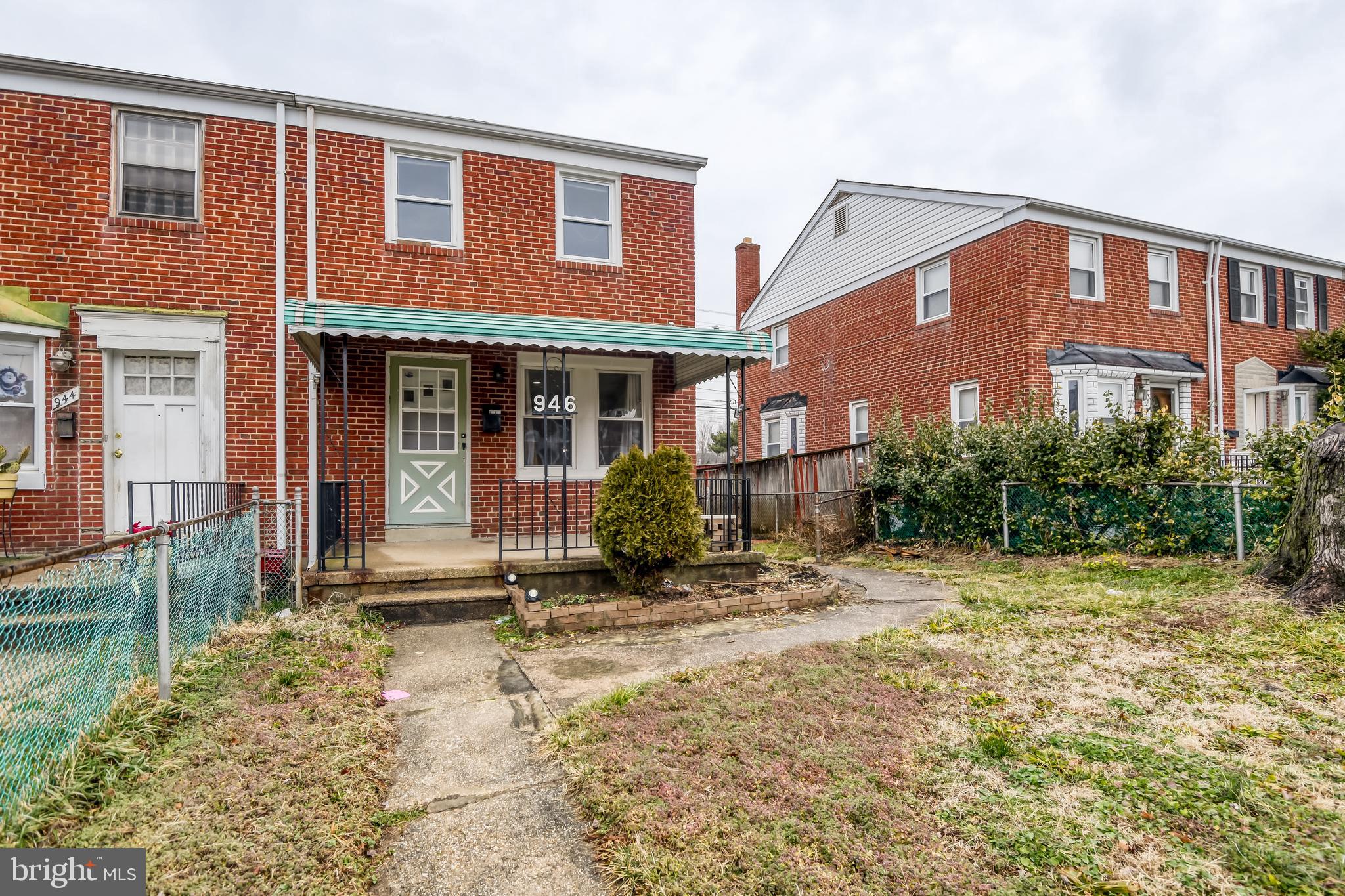 a view of a brick house with many windows next to a yard