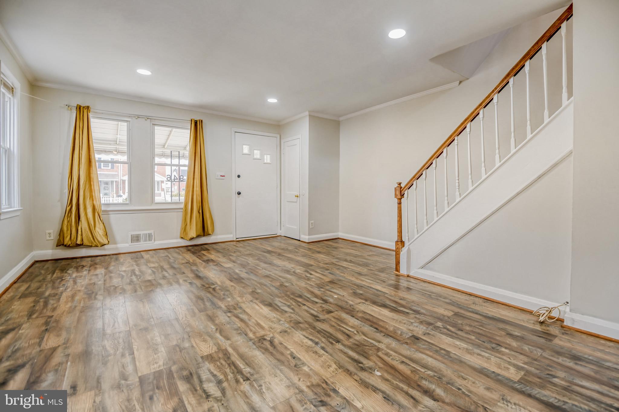 946 Middlesex Road Essex, MD 21221 - Photo 3 of 22 a view of an empty room with wooden floor and stairs