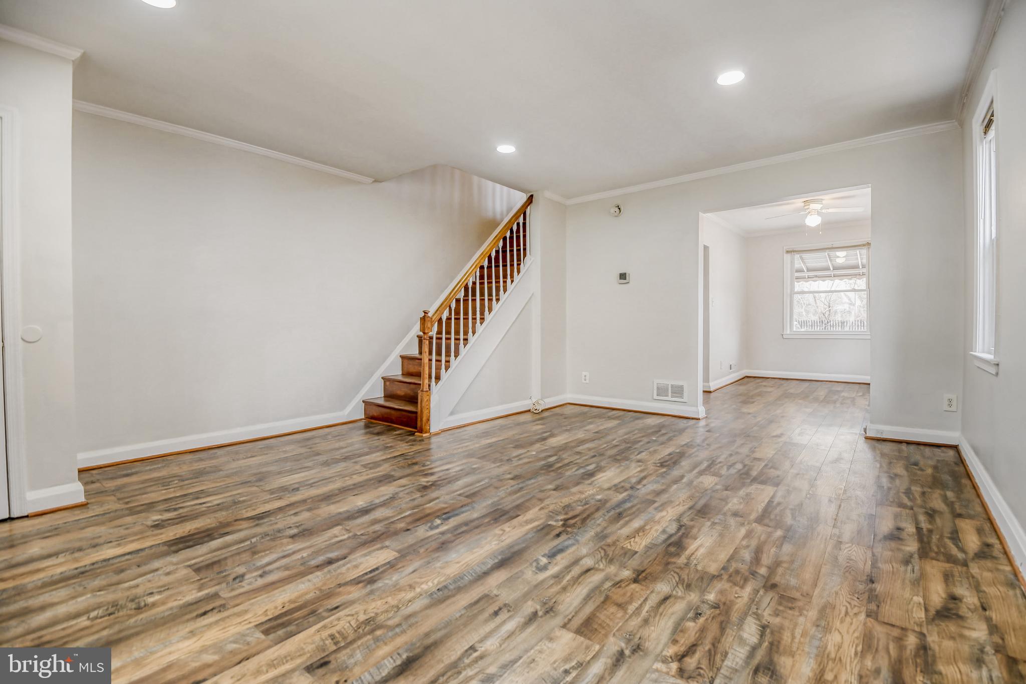 946 Middlesex Road Essex, MD 21221 - Photo 5 of 22 a view of an empty room with wooden floor and stairs