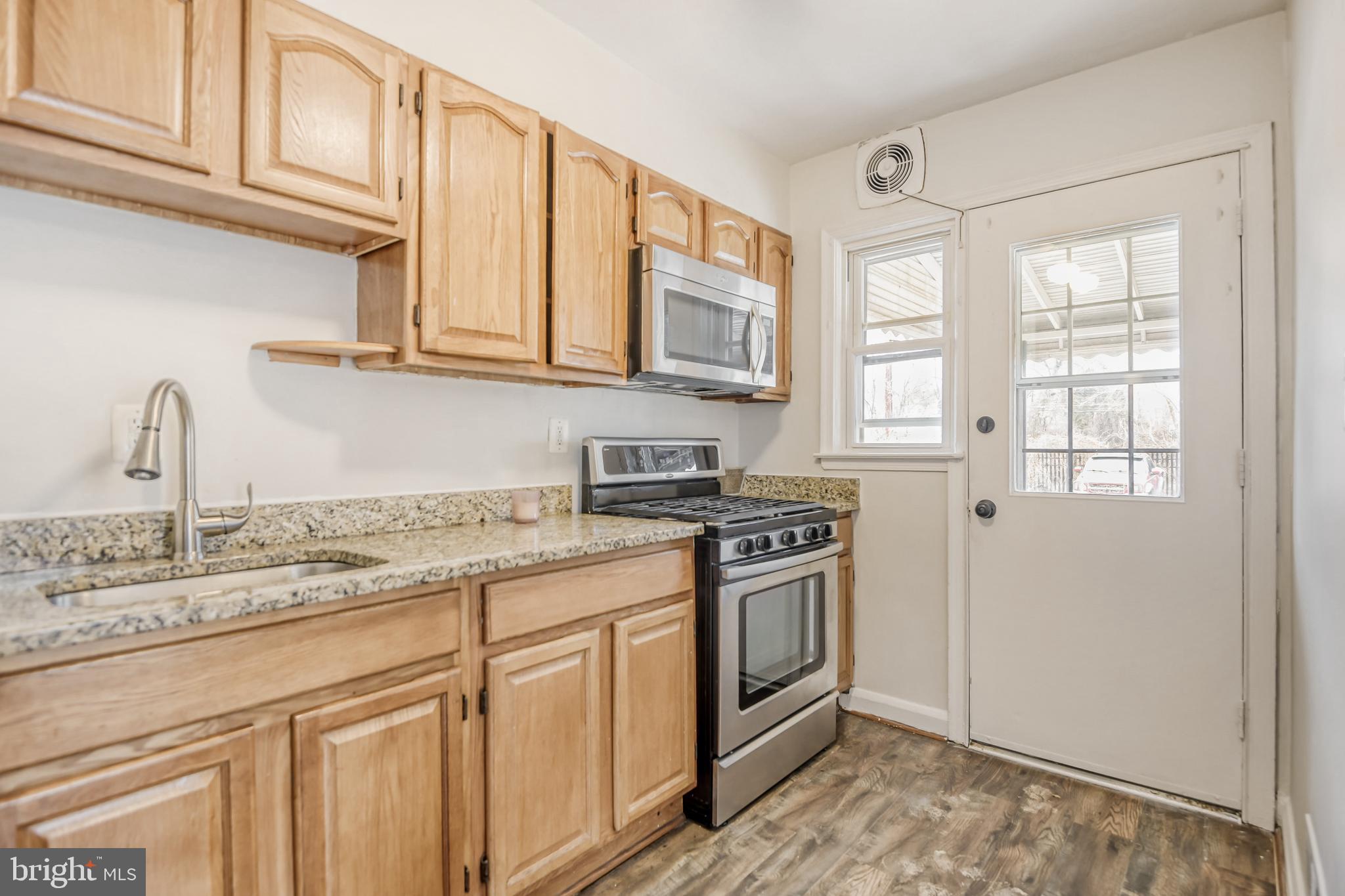 946 Middlesex Road Essex, MD 21221 - Photo 7 of 22 a kitchen with stainless steel appliances granite countertop a sink stove and cabinets