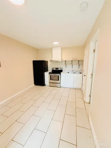 a kitchen with a stove a refrigerator and cabinets