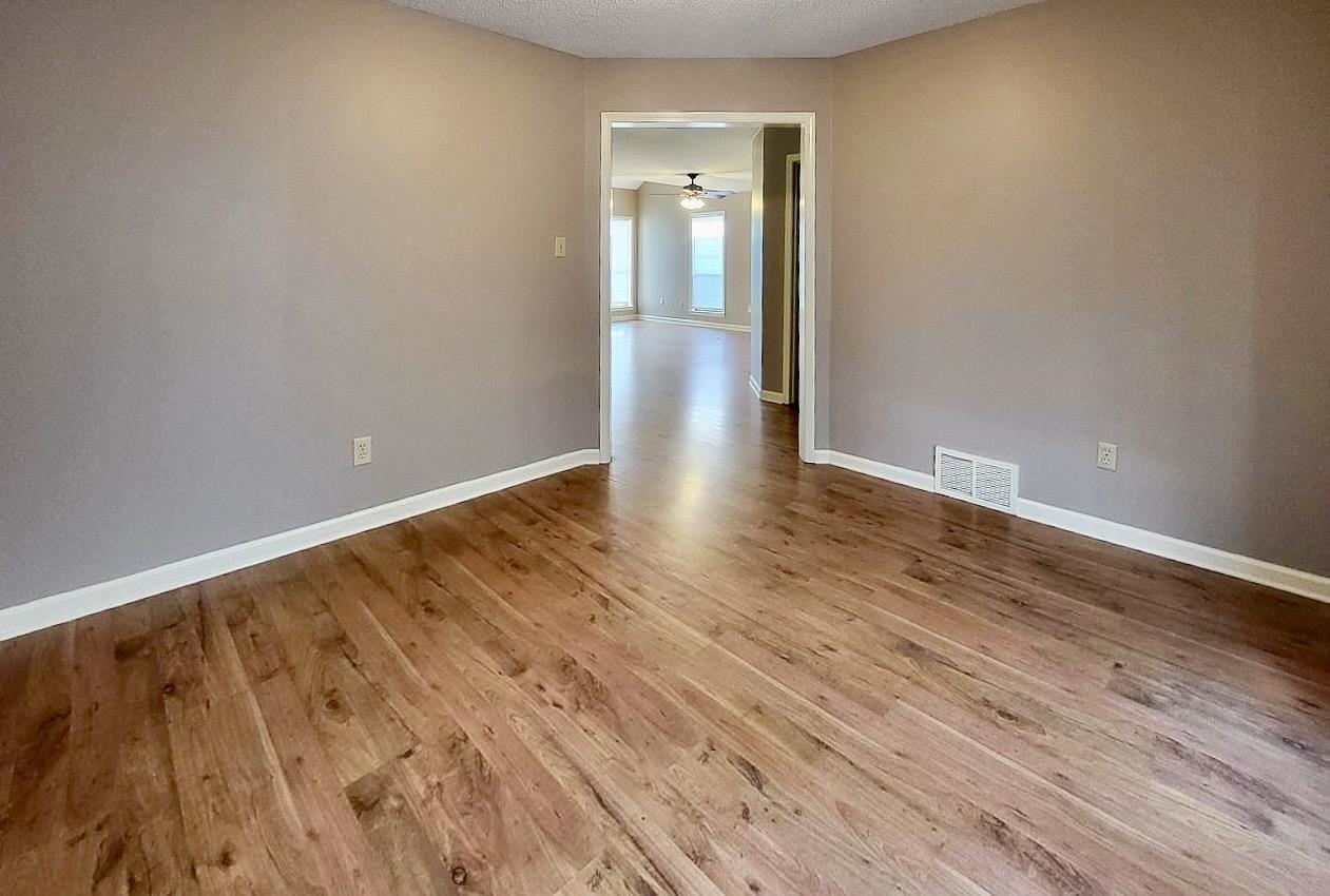 8326 Twin Rivers Drive Memphis, TN 38016 - Photo 7 of 21 Wood-finish flooring throughout, neutral wall tones, and white trim